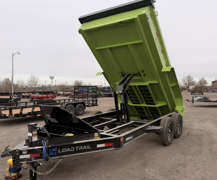 Dump trailer bed raised, showing the hydraulic scissor hoist dumping a load